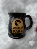 Black mug with 'Wolf Park' logo on a snowy background